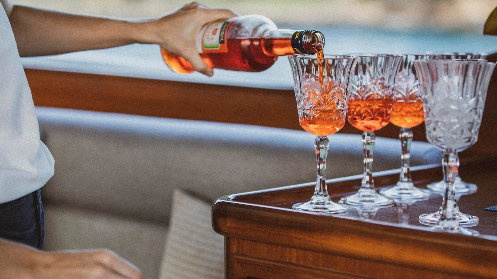 Rosé being poured into crystal glasses aboard Felix