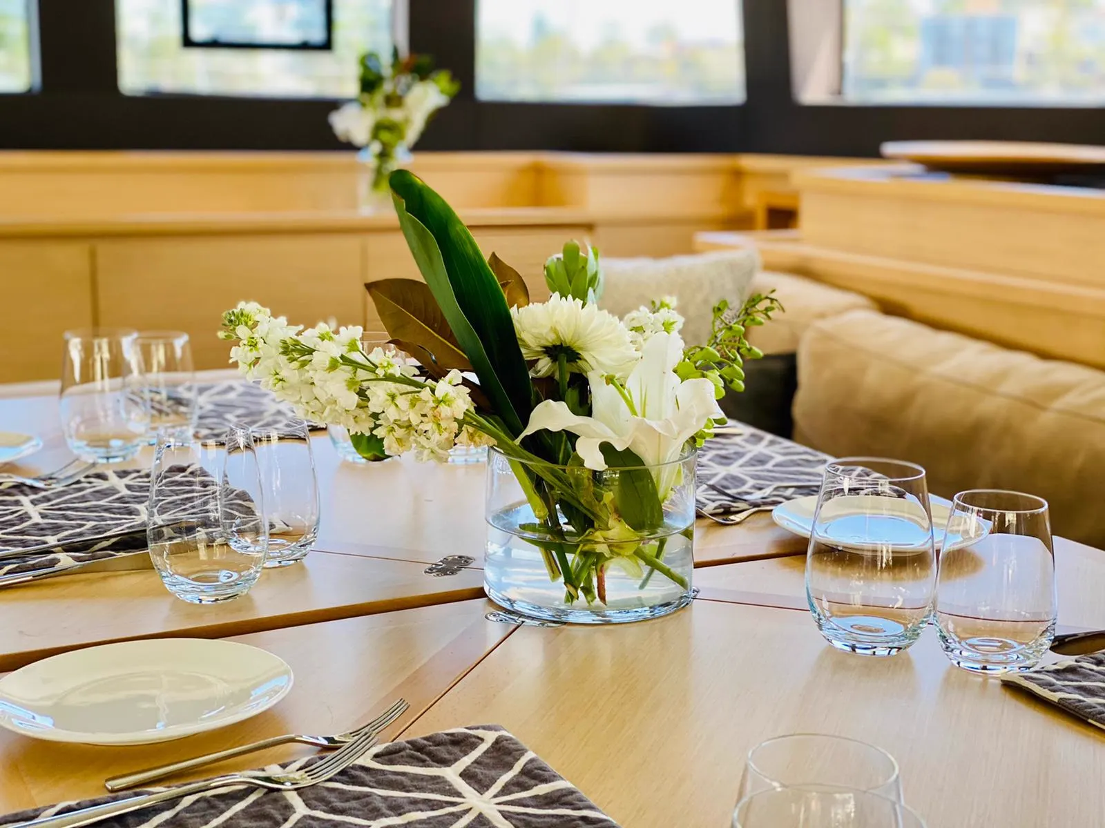 Dining table set with glassware and linen in the saloon of Mon Rêve