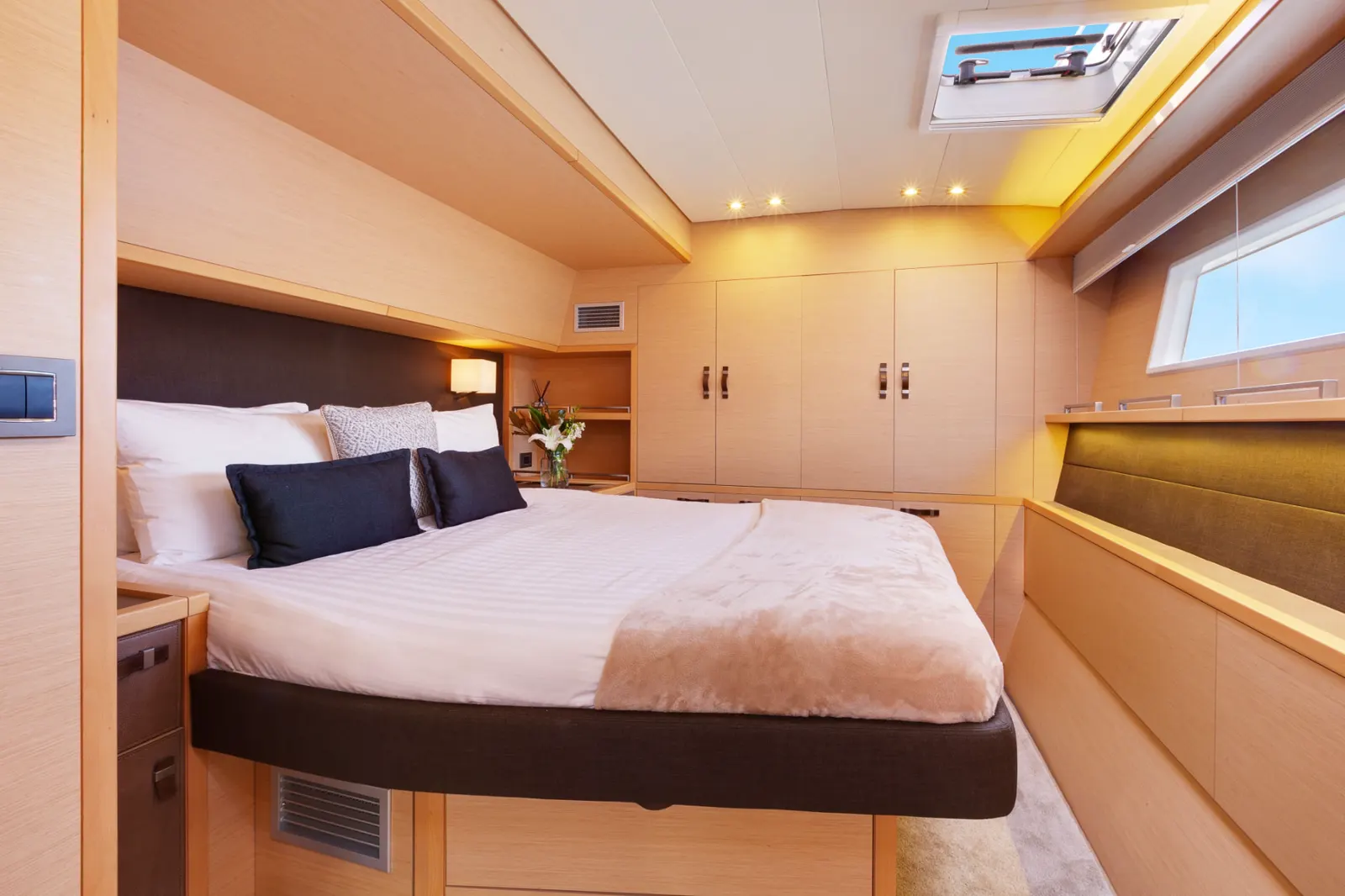 A guest stateroom aboard Mon Rêve with a double bed, timber joinery and hull windows
