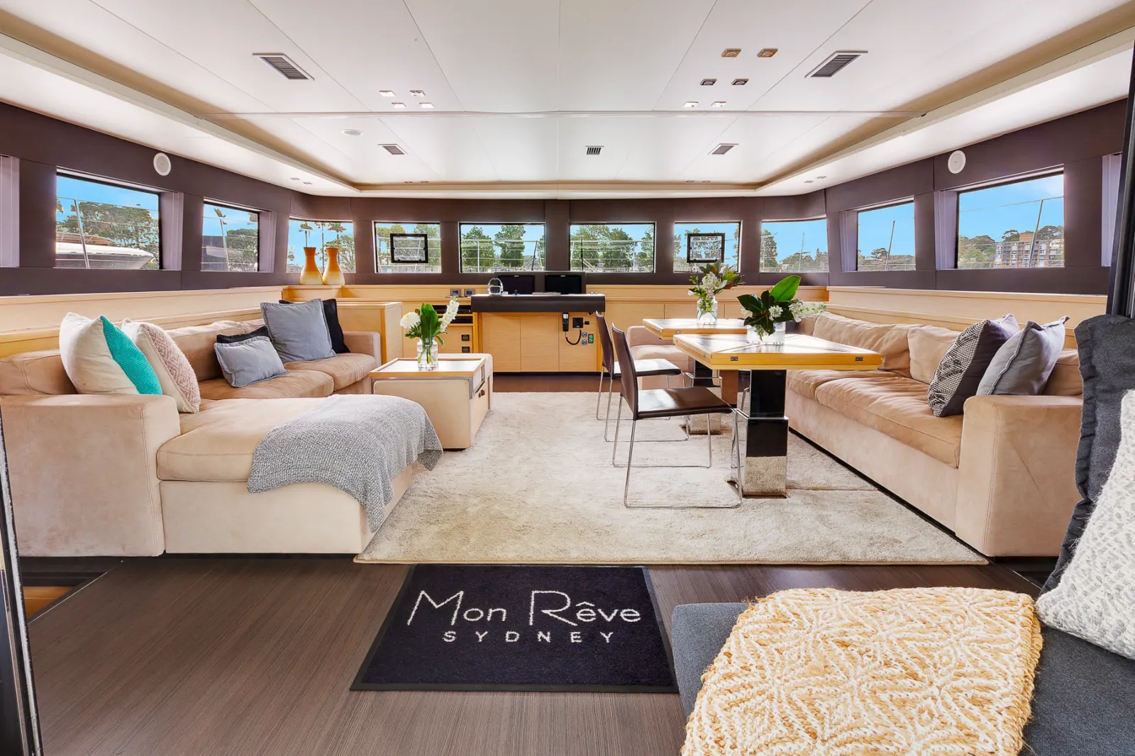 The spacious indoor saloon aboard Mon Rêve with lounge seating and dining tables