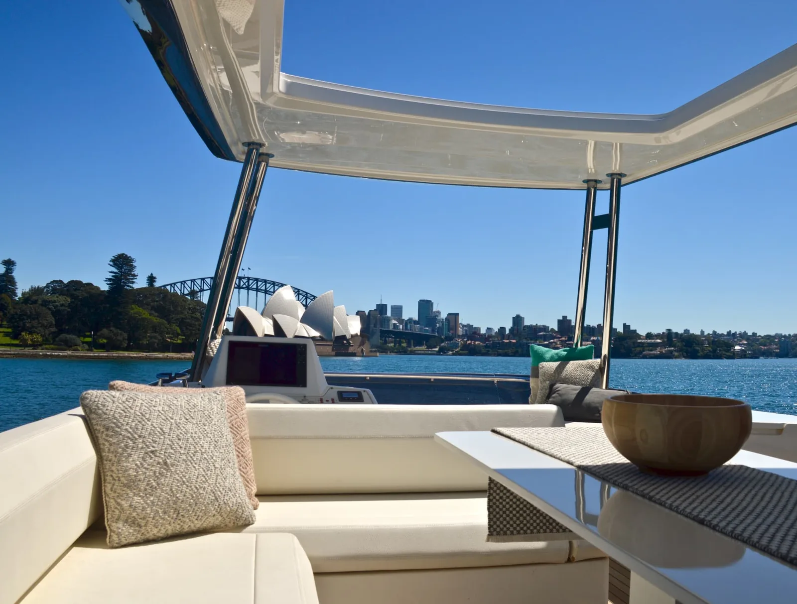 Shaded yacht seating area looking across Sydney Harbour to the Opera House and Harbour Bridge