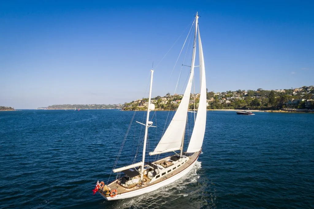 Sir Thomas Sopwith sailing under full main and headsail on Sydney Harbour, seen from above