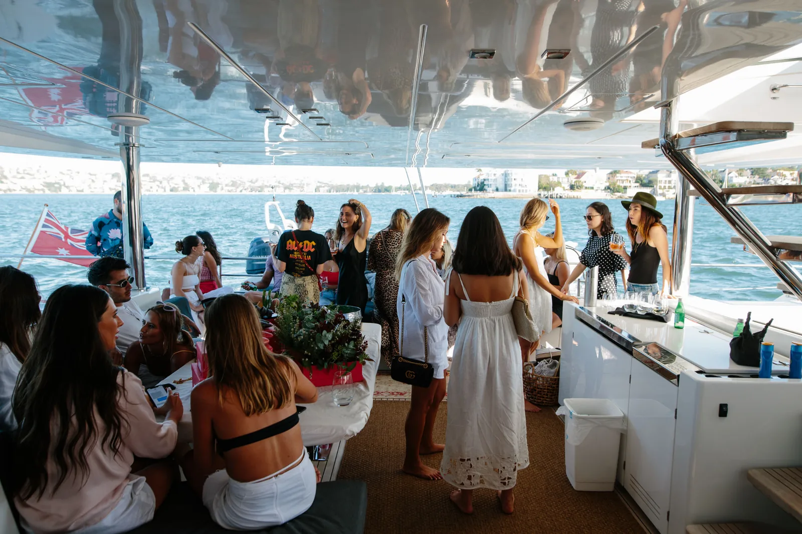 Guests gathered on the aft deck of Mon Rêve with drinks on Sydney Harbour
