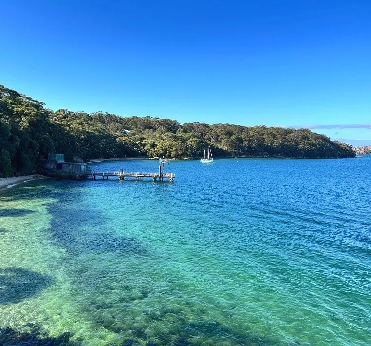 Clear turquoise water and a small jetty at Athol Bay on Sydney Harbour