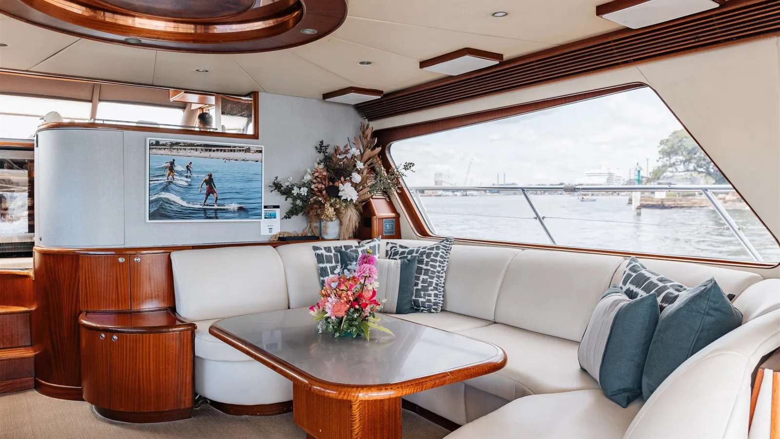 Enigma's saloon lounge and dining table with timber joinery and harbour views