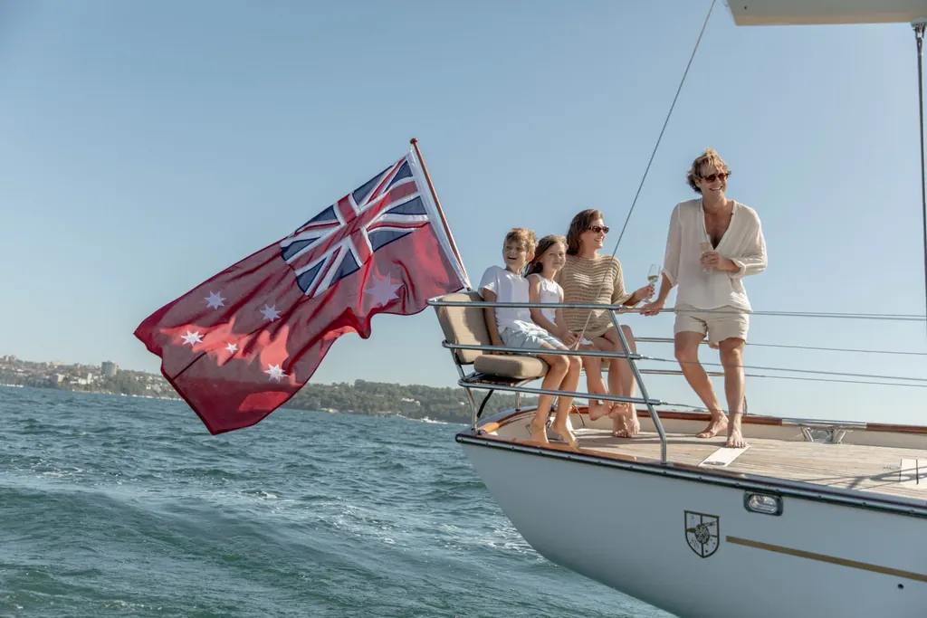 Guests relaxing on the bow of a yacht cruising Sydney Harbour