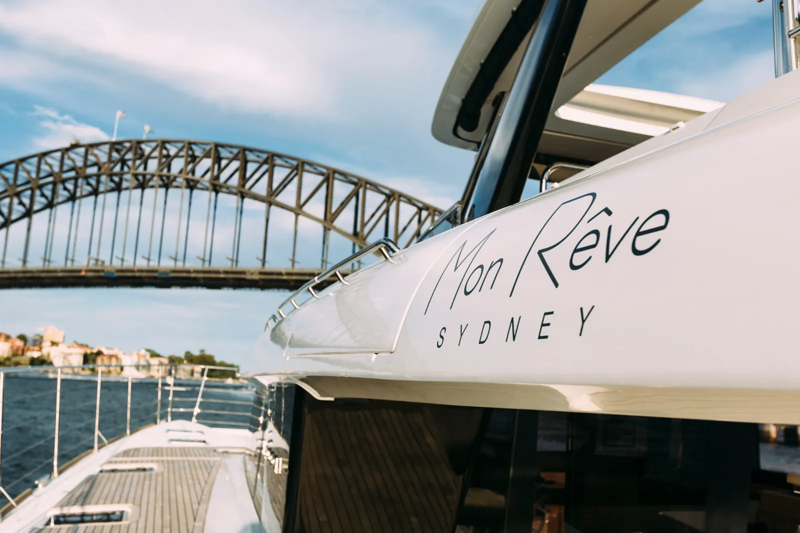 The Mon Rêve Sydney name on the hull with the Sydney Harbour Bridge behind