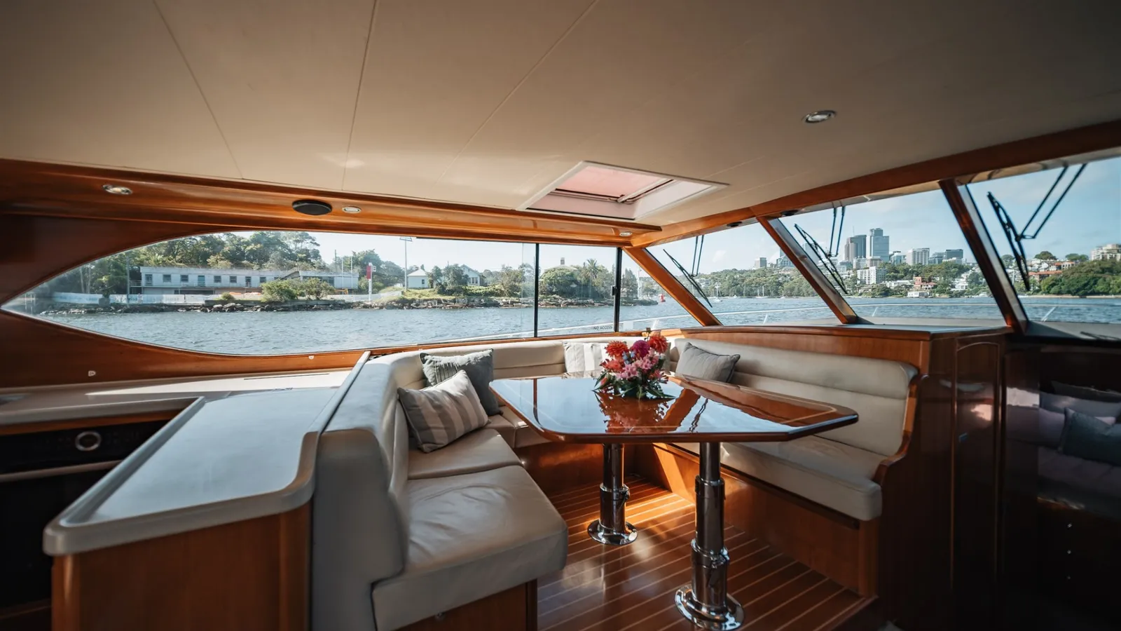 Felix's saloon with timber joinery, lounge seating and dining table beside panoramic windows