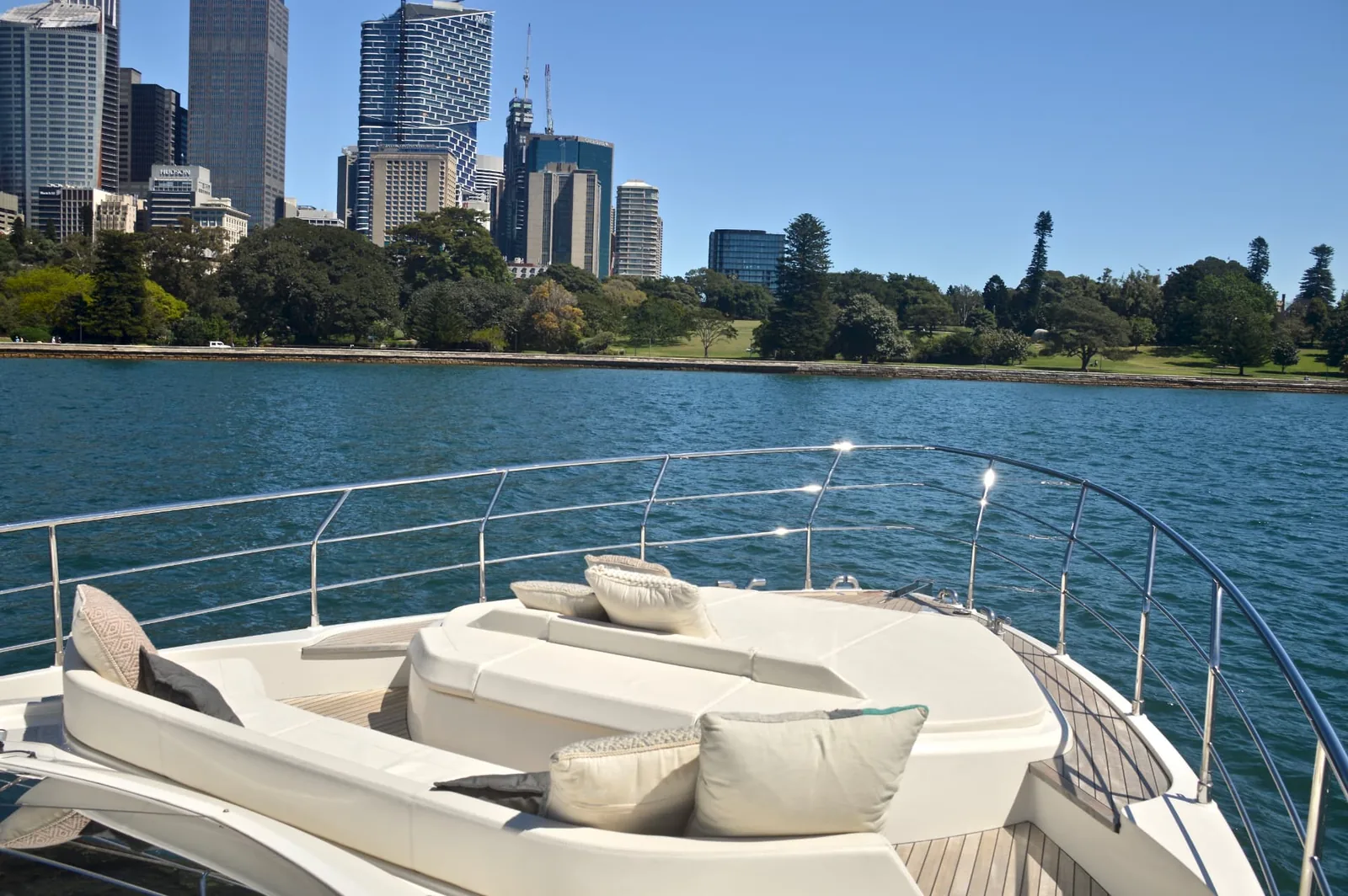 The Ribbon foredeck lounge and sunpad with cushions, overlooking Sydney Harbour and the city skyline