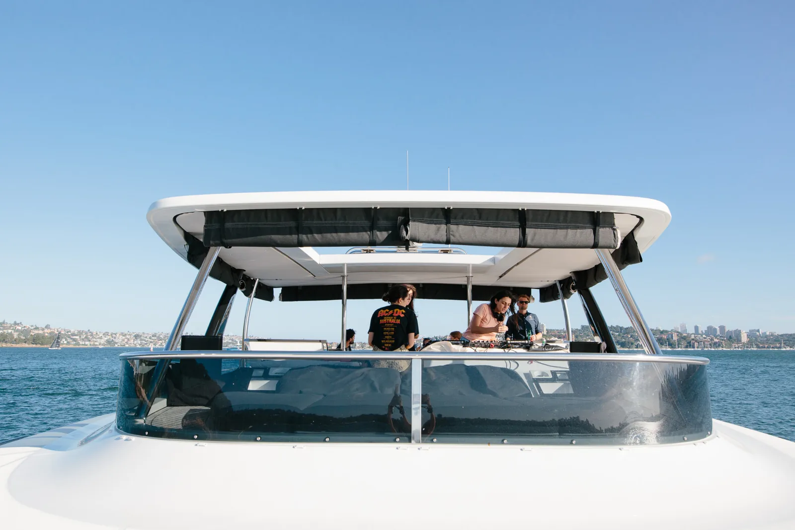 DJ and guests on Mon Rêve's flybridge with Sydney Harbour beyond